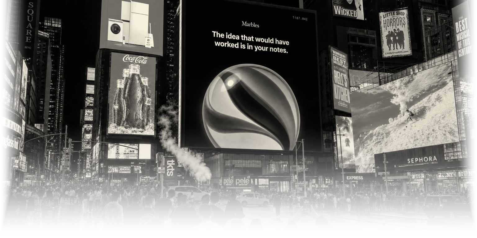 A Marbles billboard in Times Square at night, reading: The idea that would have worked is in your notes.